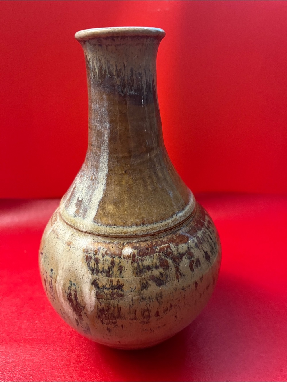 handcrafted ceramic bottle vase featuring a rounded body and a warm tan and brow